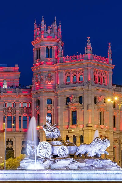 Cybele Palace or Palacio de Cibeles city hall illuminated by colors of Spanish flag