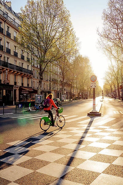 Cyclist at dawn on the deserted streets of Paris, France