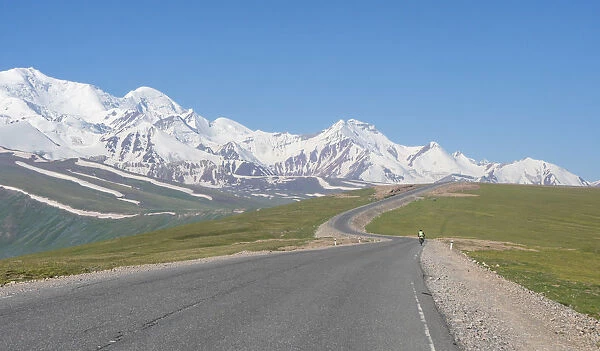 Cyclist along Irkestam pass road with Pamir peaks in the background