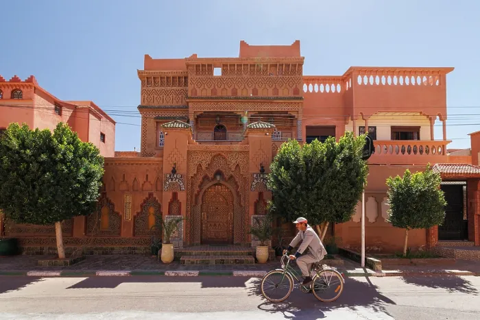Framed Print : Cyclist passing in front of ornate riad, Ouarzazate, Morocco Framed Print : Cyclist passing in front of ornate riad, Ouarzazate, Morocco