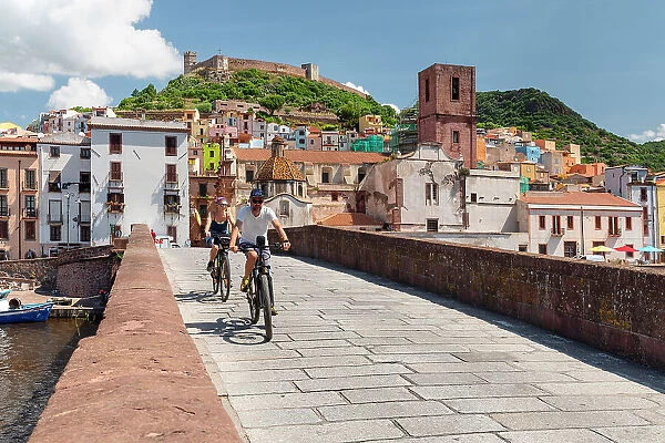 Cyclists on a bridge, Bosa, Oristano district, Sardinia, Italy