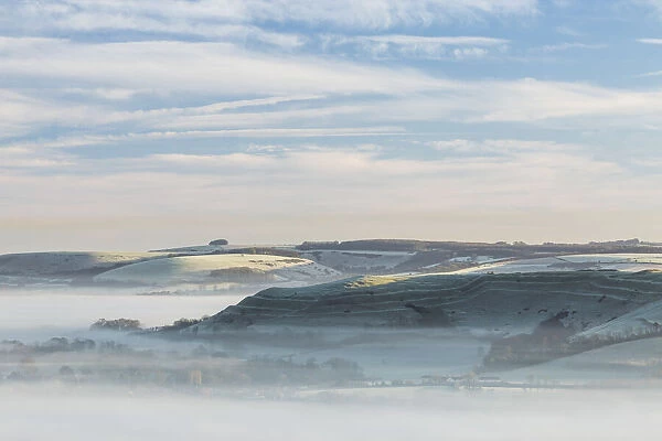 Dawn mist around Hambledon Hill from Bullbarrow Hill, Dorset, England, UK