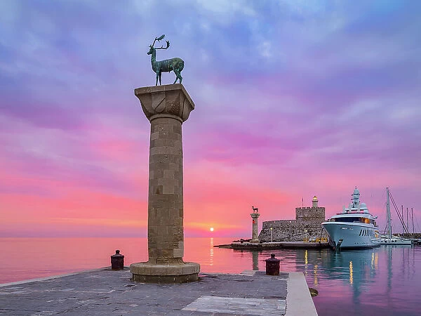 Dear and Doe on the columns at the entrance to the Mandraki Harbour, former Colossus of Rhodes location, Saint Nicholas Fortress in the background, sunrise, Rhodes City, Rhodes Island, Dodecanese, Greece