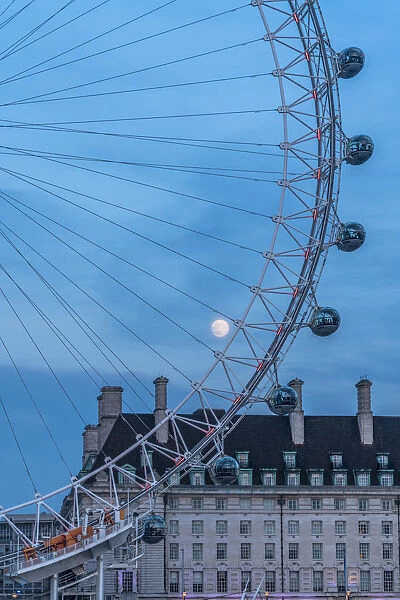Details of London Eye ferris wheel with County Hall in background under the full moon