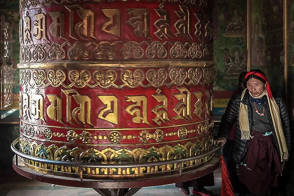 Devotee spinning prayer wheel in temple at Boudhanath Stupa, Kathmandu, Nepal