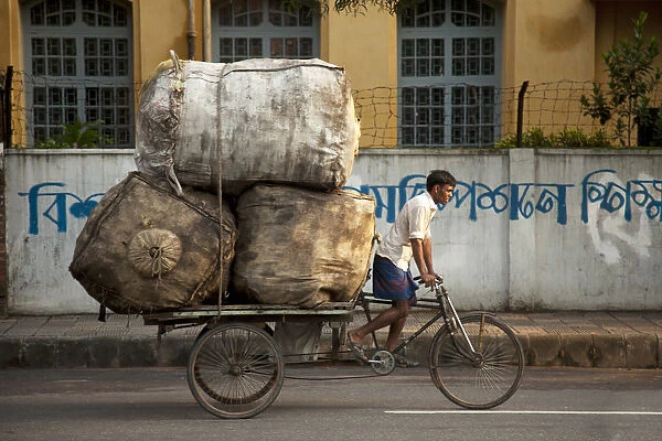 Dhaka, Bangladesh. A rickshaw rider transports goods around the capital