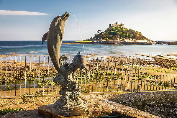 Dolphin statue overlooking St Michael`s Mount, Marazion, Cornwall, England