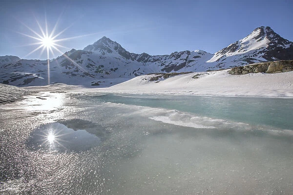 A double sun reflecting in a pool during the vernal thaw at the Lake Bianco - Gavia pass