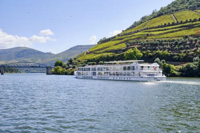 Framed Print : A Douro river cruise ship passing along the village of Pinhao