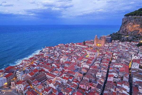 Drone view of the ancient illuminated sea village of Cefalu with the cathedral surrounding buildings, Cefalu, Palermo province, Tyrrhenian sea, Sicily, Italy