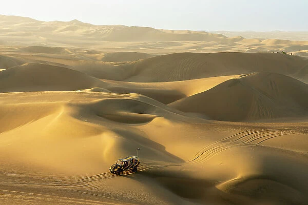 Dune buggy on sand dunes in desert at sunset, Huacachina, Ica District, Ica Province, Ica Region, Peru