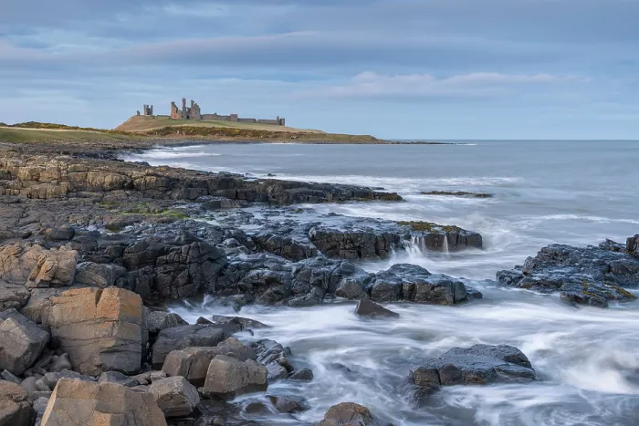 Framed Print : Dunstanburgh Castle above the rocky coastline near Craster, Northumberland, England. Winter (March) 2025