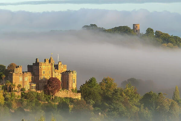 Dunster Castle and Conygar Tower emerging from morning mist, Dunster, Exmoor National Park, Somerset, England. Autumn (October) 2022