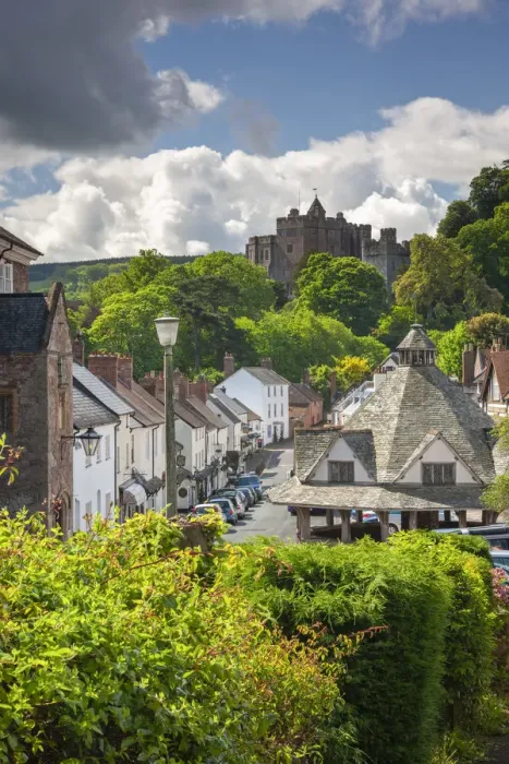 Framed Print : Dunster High Street, with the Yarn Market on the right and Dunster Castle beyond Framed Print : Dunster High Street, with the Yarn Market on the right and Dunster Castle beyond