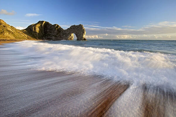 Durdle Door with surf on beach, Jurassic Coast, Dorset, England