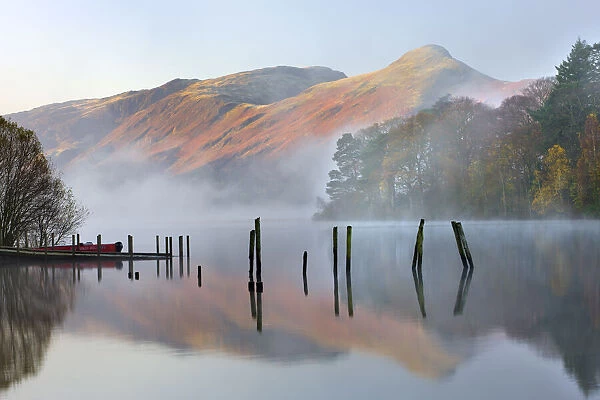 Early morning tranquil scenes of Derwent Water, with Catbells rising out of the mist in the background, Lake District National Park, Cumbria, England, UK. Autumn (November) 2009