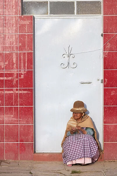 Elder woman sitted in front of a door in Copacabana, Lake Titicaca, La Paz, Bolivia
