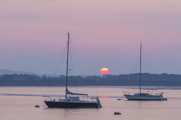England, Hampshire, Langstone, Sunrise with Two Yachts over Chichester Harbour