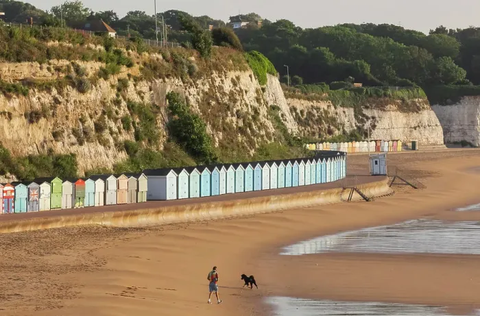 Framed Print : England, Kent, Broadstairs, Stone Bay, Long Row of Colourful Beach Huts and Dog Walker Framed Print : England, Kent, Broadstairs, Stone Bay, Long Row of Colourful Beach Huts and Dog Walker