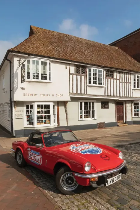 Framed Print : England, Kent, Faversham, Annual Festival of Transport, Shepherd Neame Vintage Triumph Spitfire Car in Front of The Brewery Shop and Offices Framed Print : England, Kent, Faversham, Annual Festival of Transport, Shepherd Neame Vintage Triumph Spitfire Car in Front of The Brewery Shop and Offices