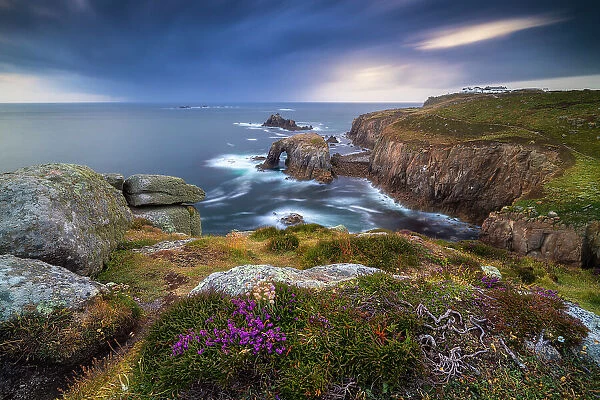 Enys Dodnan Arch and Longships lighthouse at sunset, Lands End, Cornwall, England, United Kingdom
