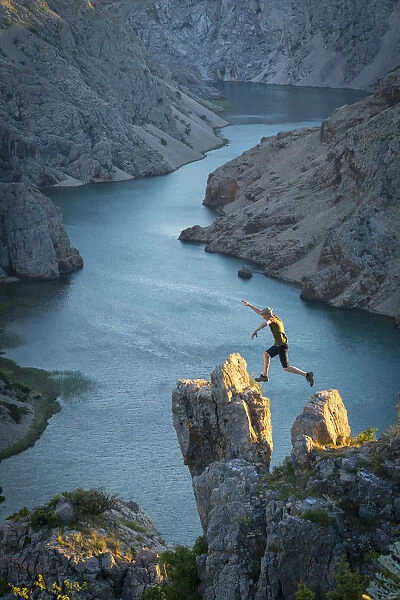 Europe, Balkan, Croatia, man with hat jumping at Zrmanja canyon