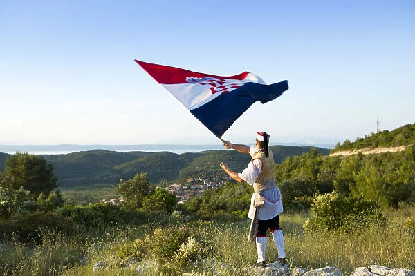 Europe, Croatia, Dalmatia, Korcula Island, Blato, a local in traditional dress waving
