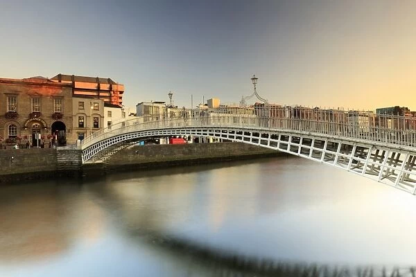 Europe; Dublin, Halfpenny bridge and Liffey river at sunset