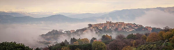 Europe, Italy, Latium. On a hiking path from Frascati watching the town of Monte Porzio Catone in the mist