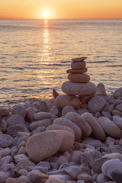 europe, Italy, Tuscany, Elba Island, a sunset at Pomonte beach with pebble cairns