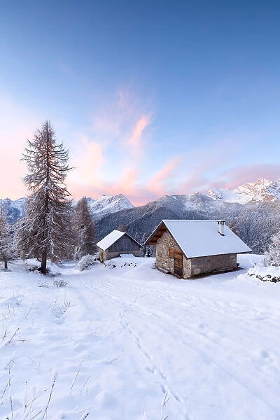 Europe, Italy, Veneto, Belluno, Dolomites. Mountain chalets in a colorful winter sunrise