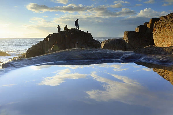 Europe, Northern Ireland, tourists visiting the Giants Causeway at sunset