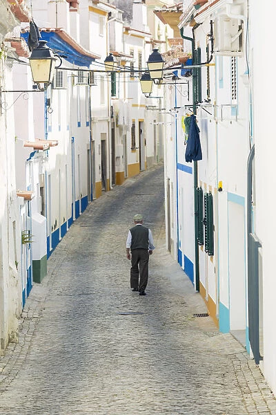 Europe, Portugal, Alentejo, Arronches, an old man walking along a cobbled street in