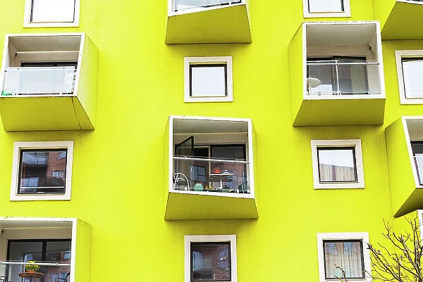 External view of a modern yellow building with windows and balconies, Amager Vest district, Copenhagen, Hovedstaden Denmark, Europe