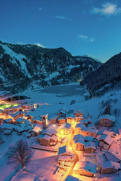 Fairy tale alpine village covered with snow at blue hour, aerial view, Isola, Madesimo, Valle Spluga, Valtellina, Lombardy, Italy