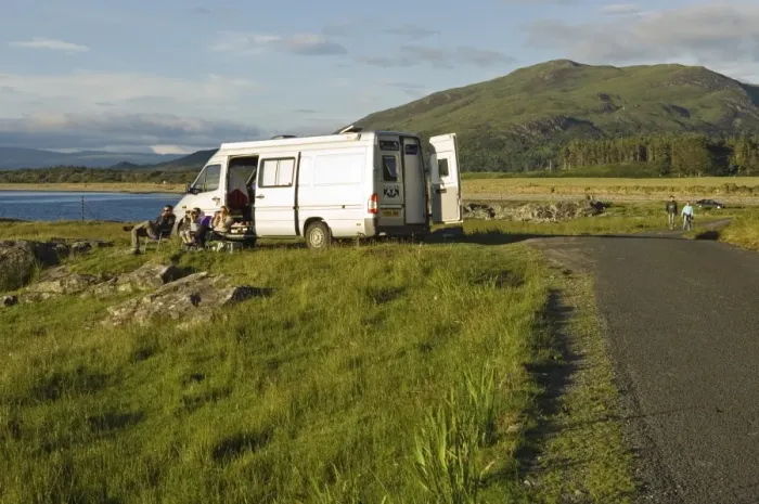 Framed Print : A family on a camping holiday sit outside their campervan