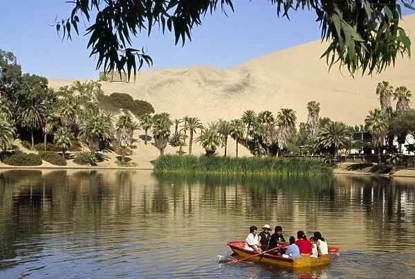 A family rows out onto the oasis lagoon of Huacachina