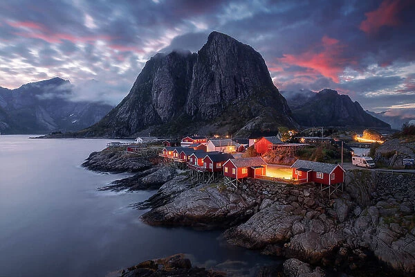 The famous red cabins of Hamnoy catching the last light of the day on a explosive summer sunset. Lofoten Islands, Norway