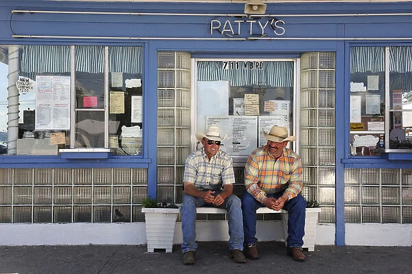 Two farm workers sat outside a ice cream parlour, Western Nebraska, USA