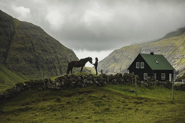 A Faroese girl with her horse in Saksun. Streymoy, Faroe Islands