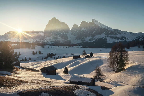The first light of the day hitting the snowy meadows of the Alpe di Siusi (Seiser Alm) on a late winter morning. Dolomites, Italy