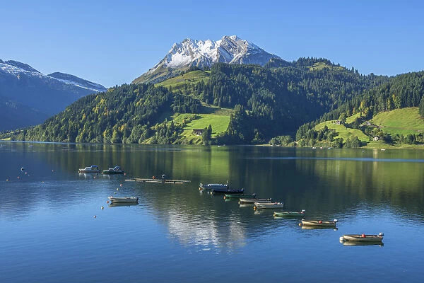 Fisher boats on Lake Wagital with Fluebrig mountain in the Glarner Alps at fall, Innerthal