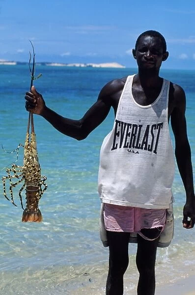 Fisherman with crayfish on the beach at Benguerra Island