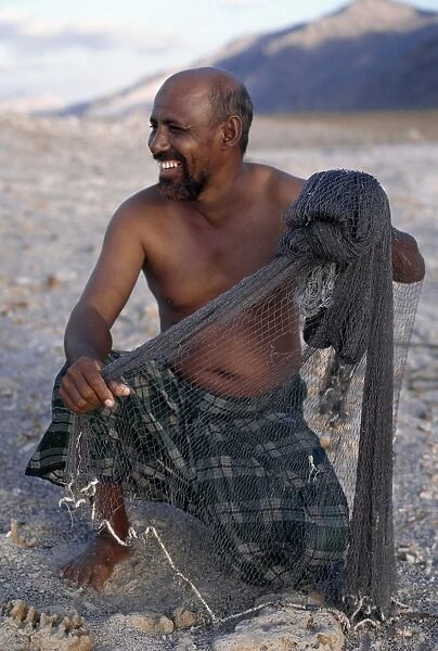 A fisherman near Di Hamri with his weighted throwing net