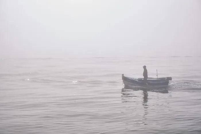 Framed Print : Fishing boat in a foggy morning coming from the sea. Setubal, Portugal