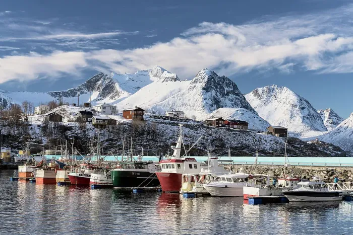 Framed Print : Fishing boats moored in the harbor surrounded by snowcapped mountains, Husoy, Senja, Troms county, Norway