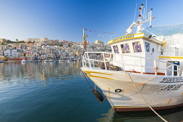 Fishing boats moored in the harbour surrounded by blue sea and the old town Sciacca