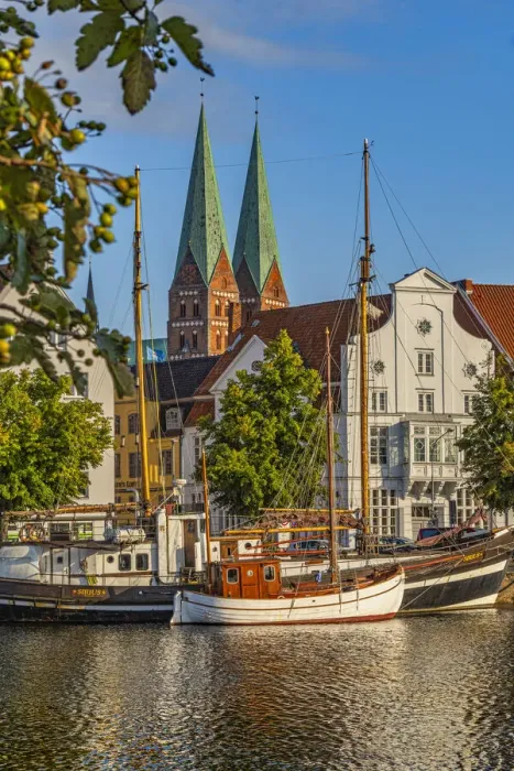 Framed Print : Fishing and tourism boats moored on the river Trave & the church of Santa Maria Framed Print : Fishing and tourism boats moored on the river Trave & the church of Santa Maria