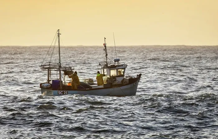 Framed Print : Fishing trawler heading out to sea at sunrise, from Cadgwith, Lizard Peninsula, Cornwall, England