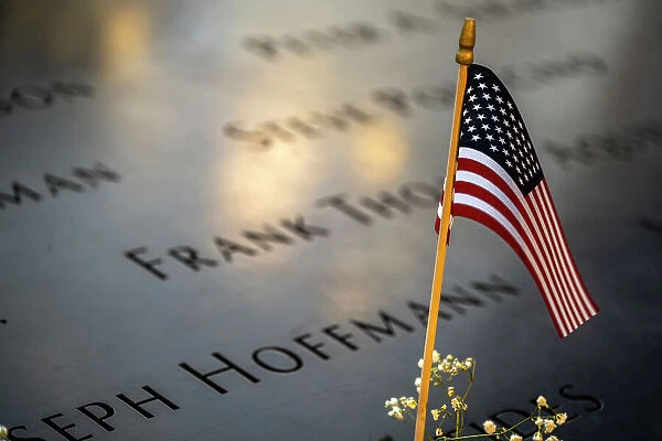 US flag on the parapet boarding the pool of the National September 11 Memorial & Museum, Manhattan, New York, USA